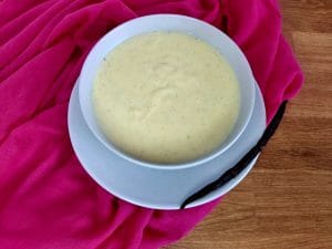 Vanilla Custard in a bowl next to a Vanilla bean 