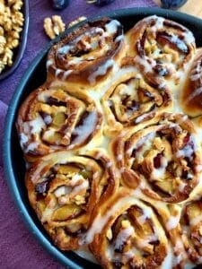 Close-up of Plum Cinnamon Rolls drizzled with a glaze.