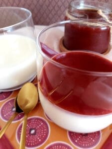 Panna Cotta in a glass on a decorative plate.