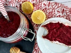 Mixed Berry Chia Jam in a glass jar. Next to it a slice of bread topped with the Jam.