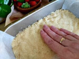 Pat the cake batter evenly in the prepared baking tin.