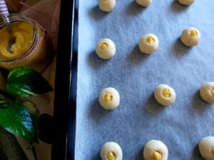 Filled Thumbprint Cookies on a baking tray ready for the oven.